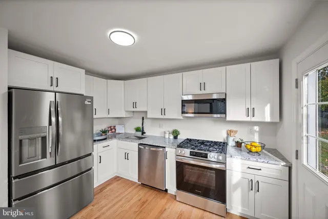 a kitchen with stainless steel appliances granite countertop a refrigerator sink and stove