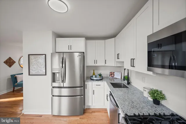a kitchen with stainless steel appliances granite countertop a refrigerator sink and stove