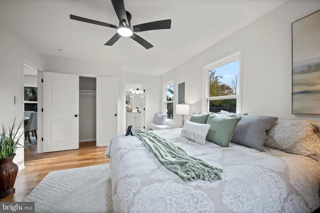 a bedroom with a large bed a chandelier and a window