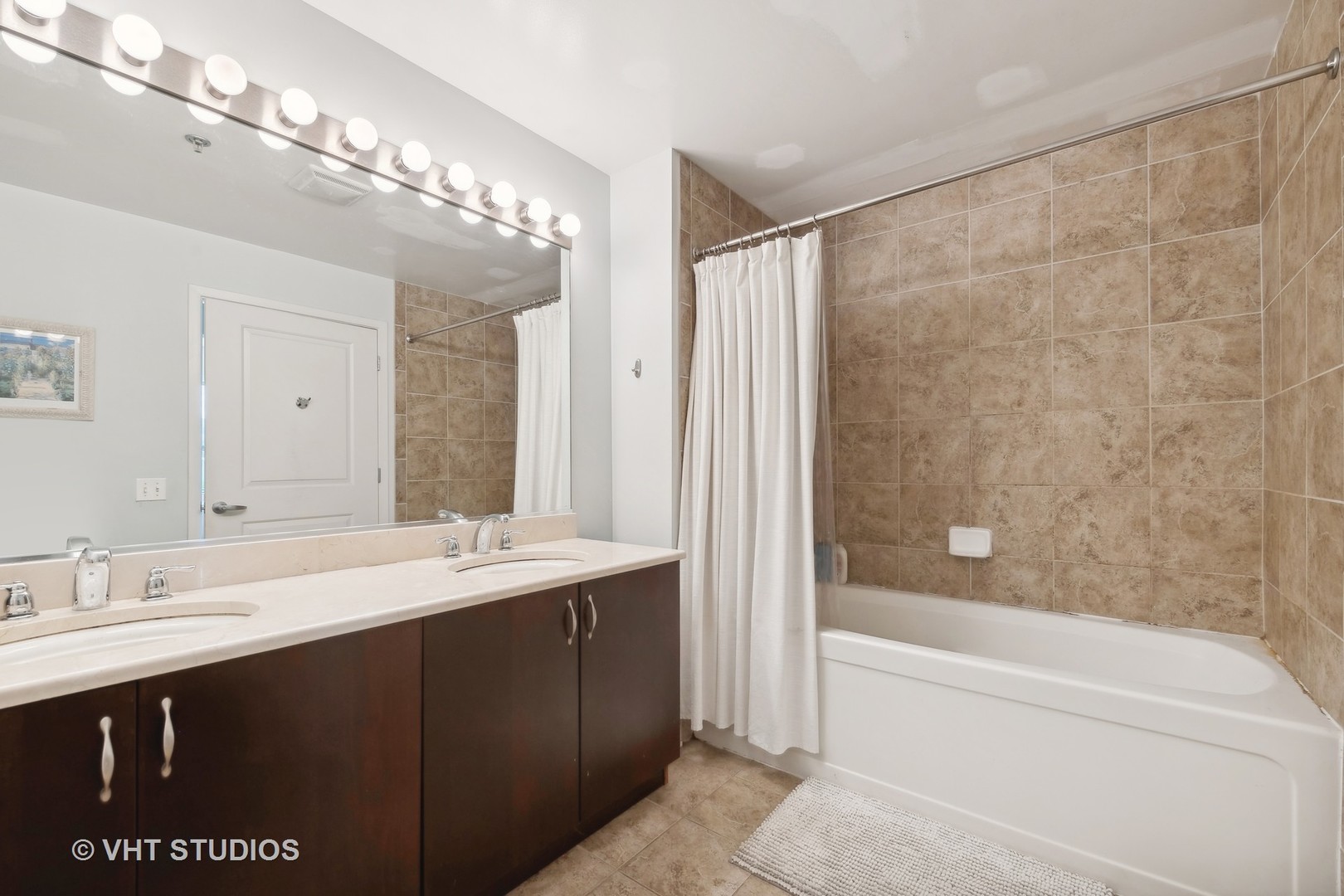 437 West Division Street, Unit 618 Chicago, IL 60610 - Photo 9 of 17 a spacious bathroom with a shower a sink and a mirror