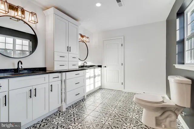 a spacious bathroom with a toilet a sink and a mirror