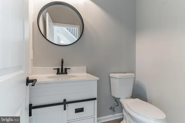 a bathroom with a toilet a sink and a mirror