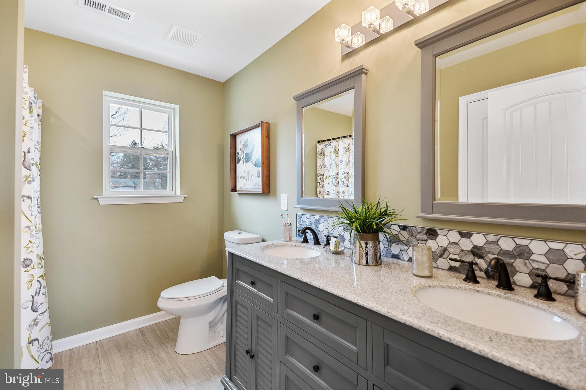 1021 West Maple Avenue Langhorne, PA 19047 - Photo 35 of 37 a bathroom with double vanity sinks a toilet and a mirror