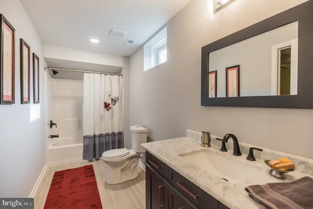 a en suite bathroom with a granite countertop sink and a mirror