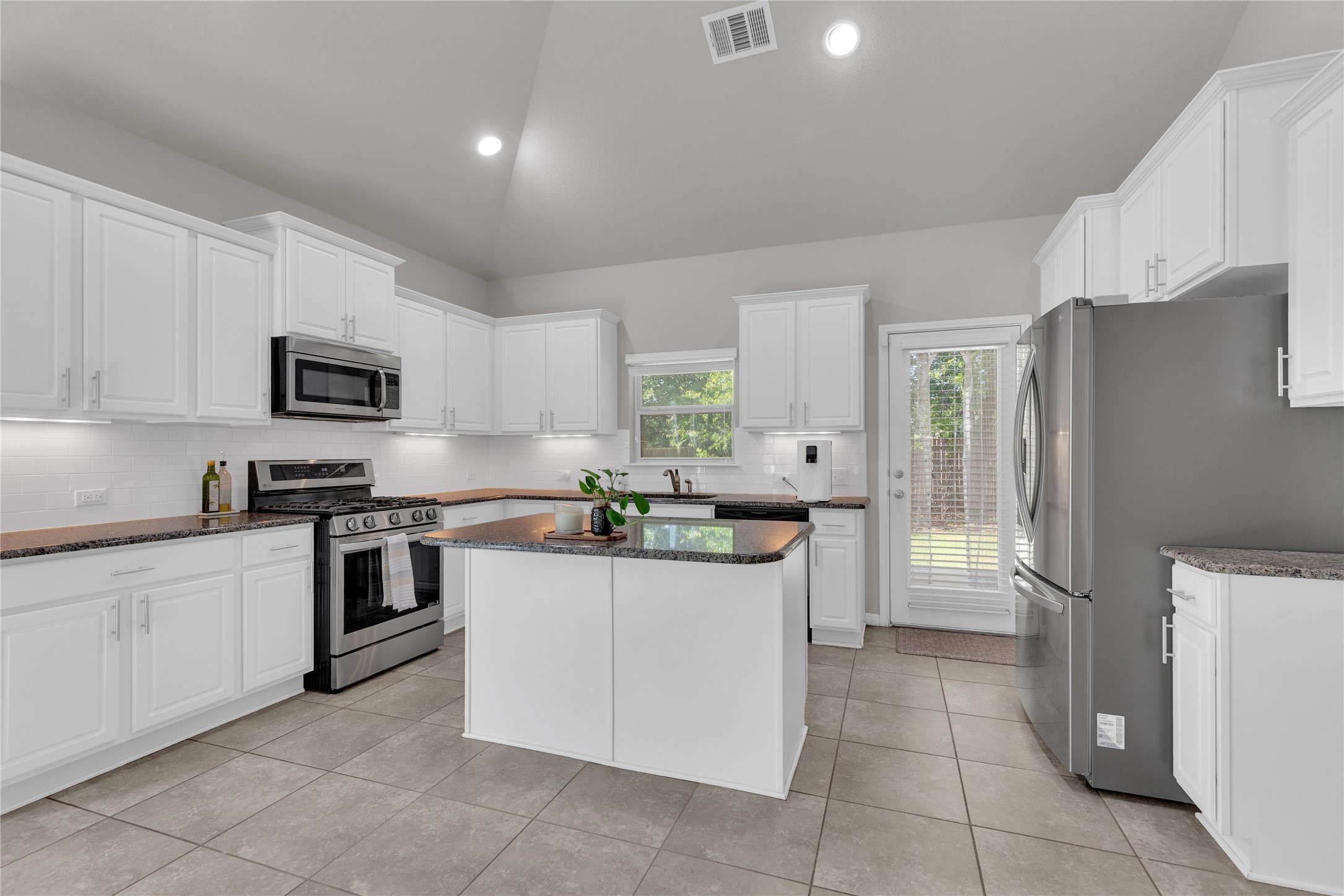 721 Schefer Street Leander, TX 78641 - Photo 11 of 38 a kitchen with stainless steel appliances granite countertop a refrigerator and a stove top oven
