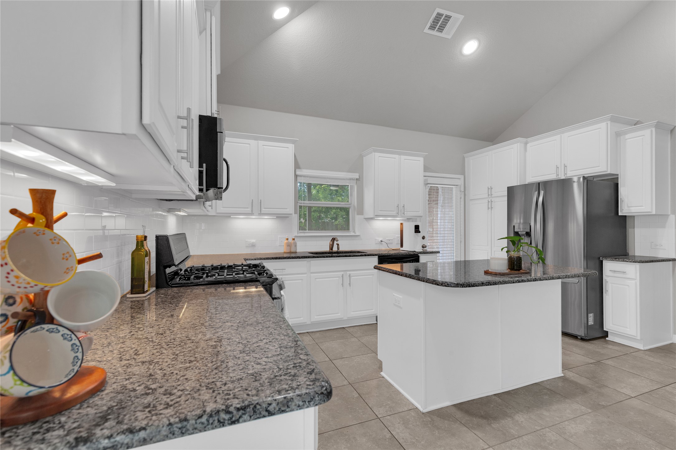 721 Schefer Street Leander, TX 78641 - Photo 12 of 38 a kitchen with stainless steel appliances granite countertop a sink a stove and a refrigerator