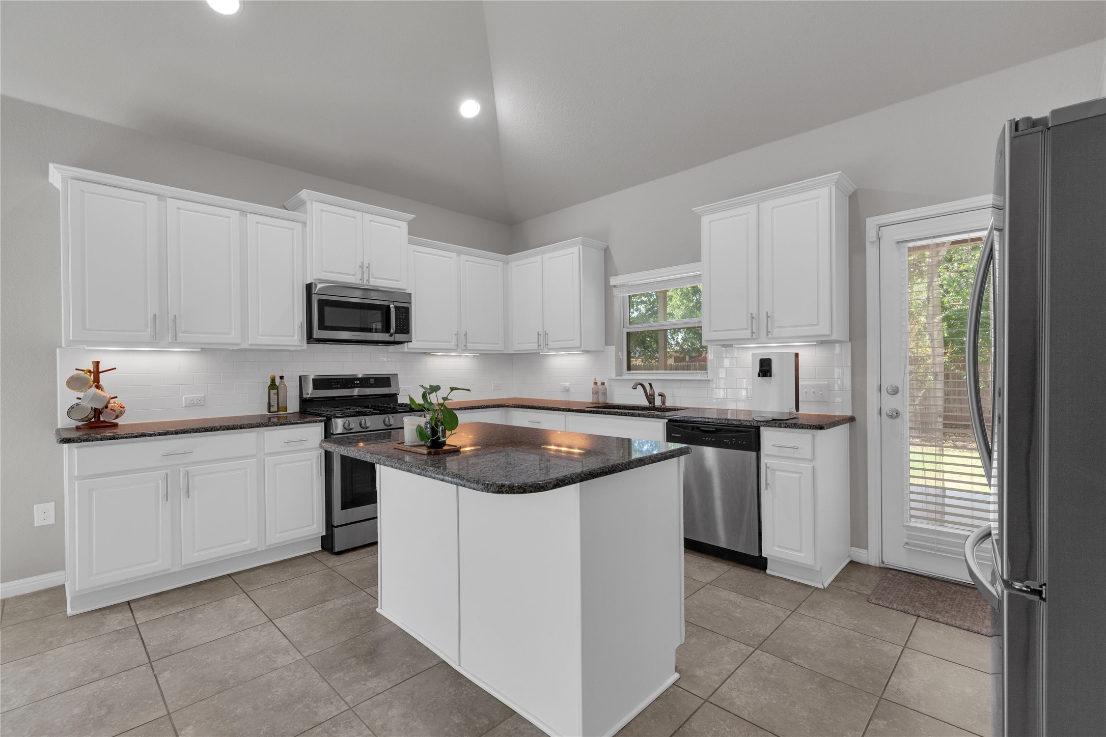 721 Schefer Street Leander, TX 78641 - Photo 15 of 38 a kitchen with cabinets appliances a sink and a window
