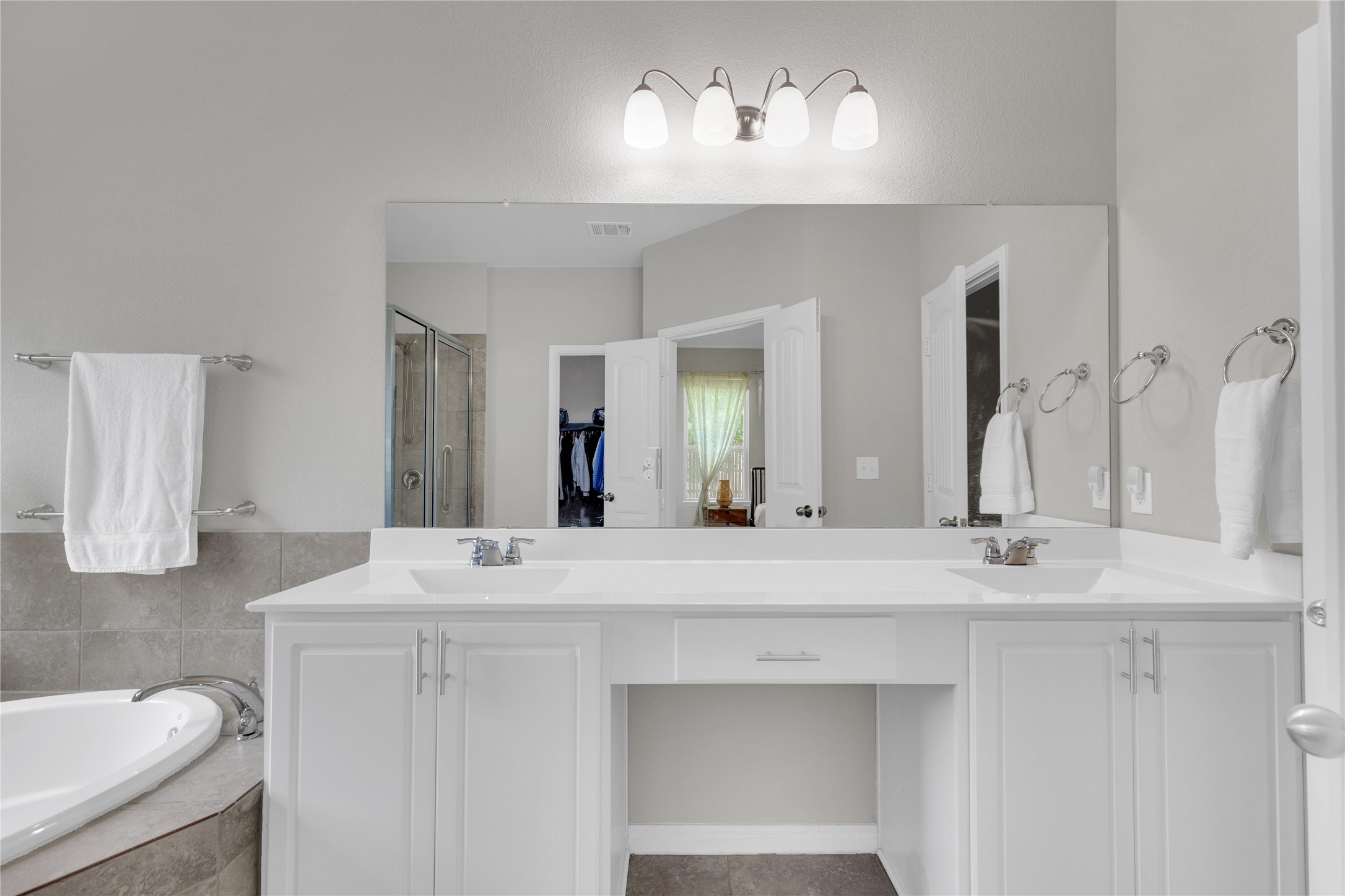 721 Schefer Street Leander, TX 78641 - Photo 19 of 38 a bathroom with double vanity sinks a vanity a lamp and a mirror
