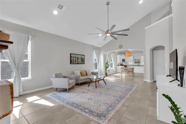 a living room with furniture a flat screen tv and a table