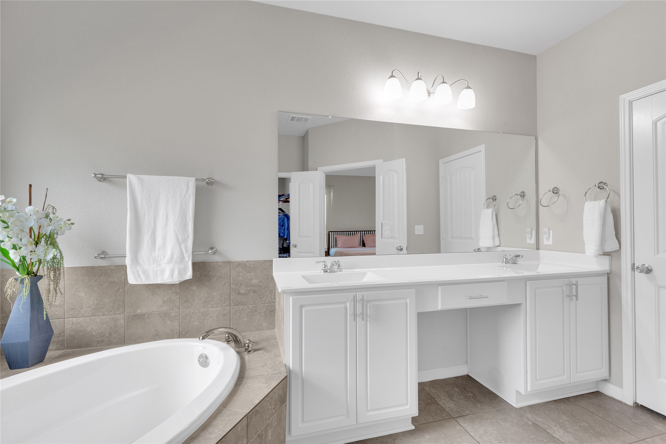 721 Schefer Street Leander, TX 78641 - Photo 21 of 38 a bathroom with a bathtub a double vanity sink and a large mirror