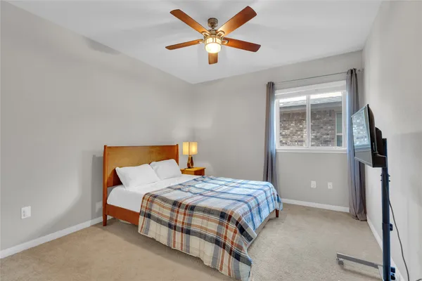 a bedroom with a bed and a ceiling fan