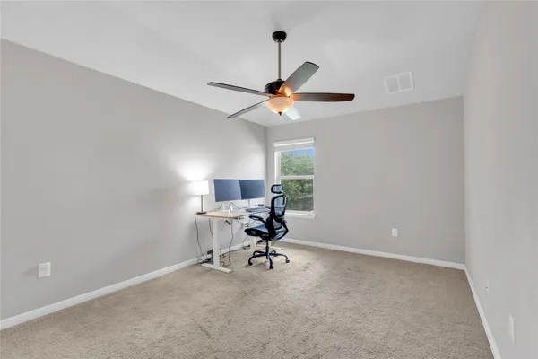 a workspace with furniture and a ceiling fan