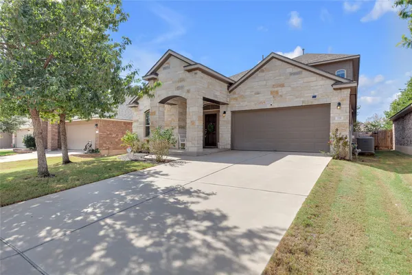 a front view of a house with a yard and garage