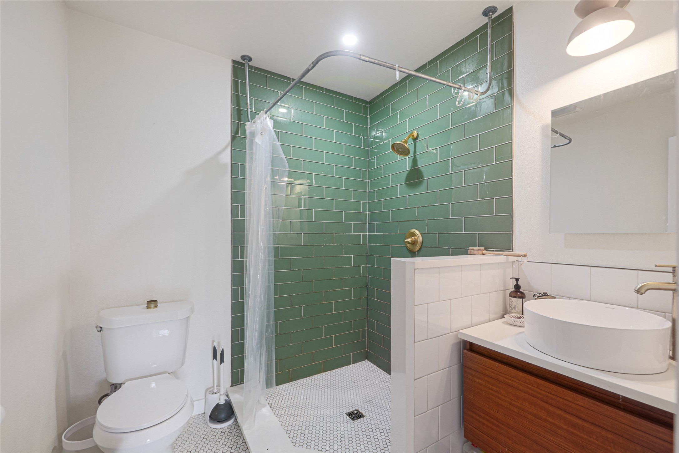 4607 Evans Avenue, Unit B Austin, TX 78751 - Photo 15 of 34 Shower with green subway tile surround, hexagonal floor tiling, and brass fixtures