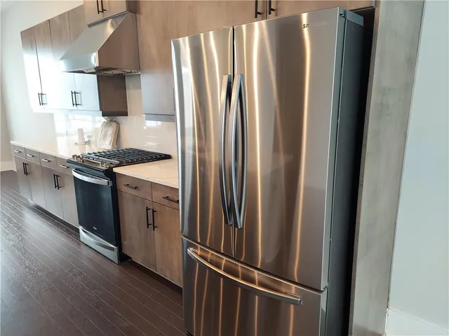 a kitchen with stainless steel appliances granite countertop a refrigerator and a sink