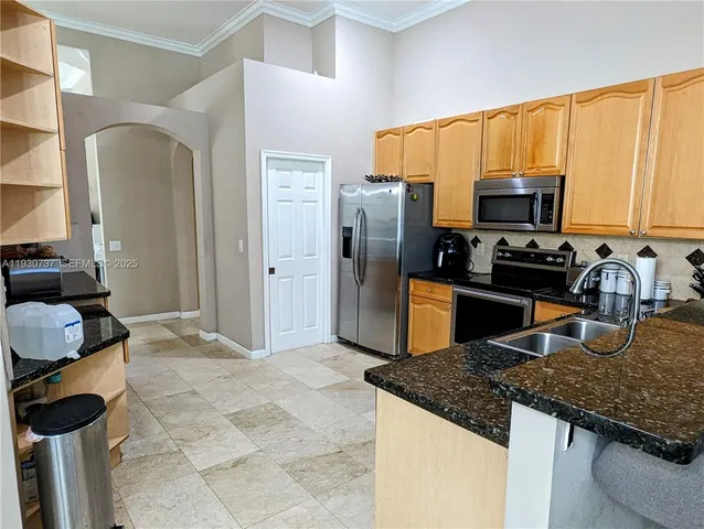 a kitchen with stainless steel appliances granite countertop a sink refrigerator and microwave
