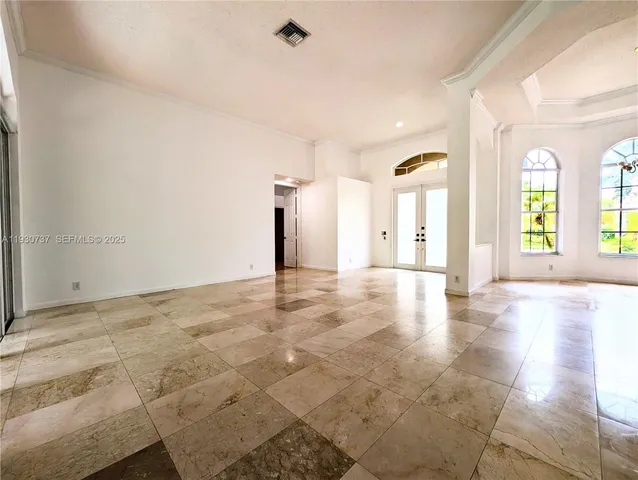 a view of a big room with wooden floor and windows