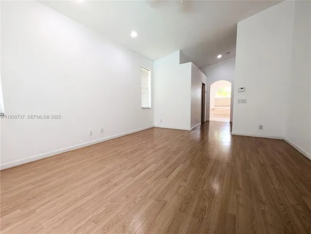 a view of empty room with wooden floor