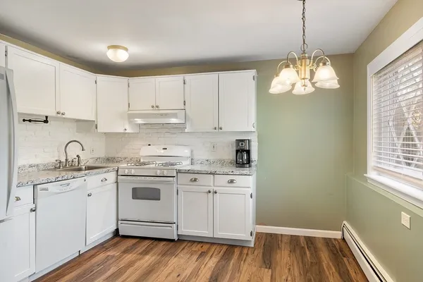 a kitchen with stainless steel appliances granite countertop a sink cabinets a refrigerator and window