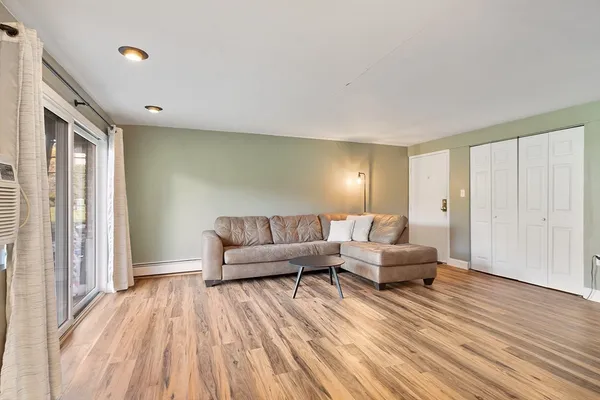 a living room with furniture and a wooden floor