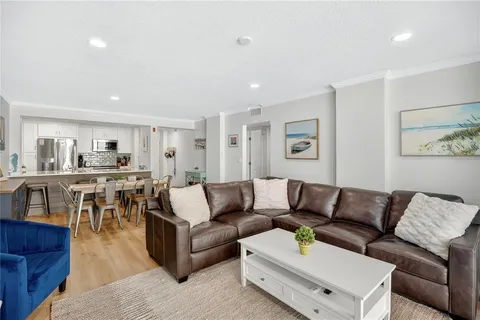 a living room with furniture and view of kitchen