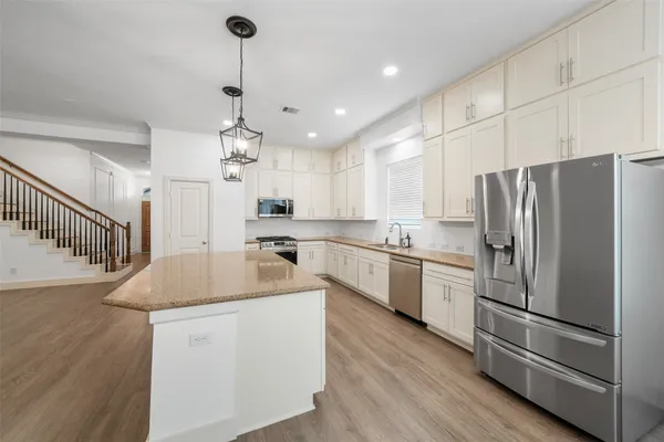 a kitchen with kitchen island white cabinets and stainless steel appliances