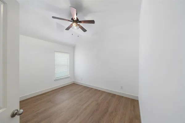 a view of a room with wooden floor and white walls