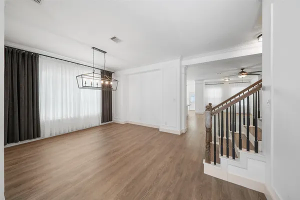 a view of a hallway with wooden floor and staircase