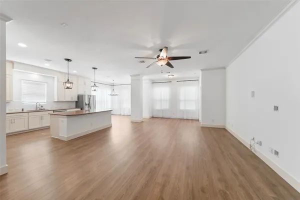 a large kitchen with cabinets wooden floor and stainless steel appliances