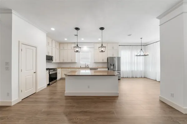 a large kitchen with cabinets and wooden floor
