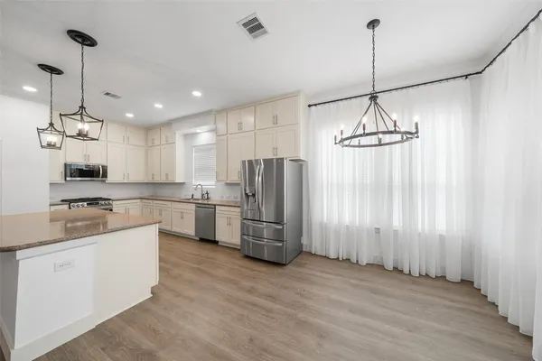 a kitchen with refrigerator and cabinets