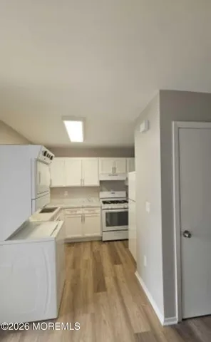 a kitchen with granite countertop a stove top oven and cabinets