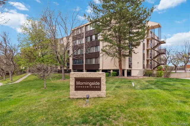 a view of a house with a yard and a large tree