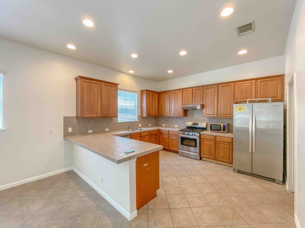609 West 37th Street Austin, TX 78705 - Photo 3 of 38 a large kitchen with stainless steel appliances granite countertop a large counter top and a stove top oven