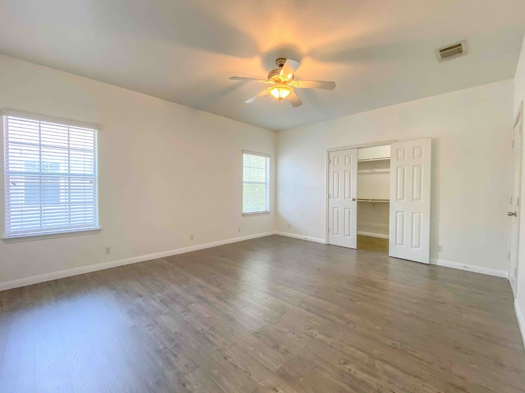 609 West 37th Street Austin, TX 78705 - Photo 4 of 38 an empty room with wooden floor chandelier fan and windows