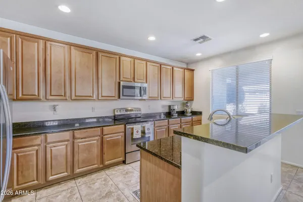 a kitchen with stainless steel appliances granite countertop a sink stove and cabinets