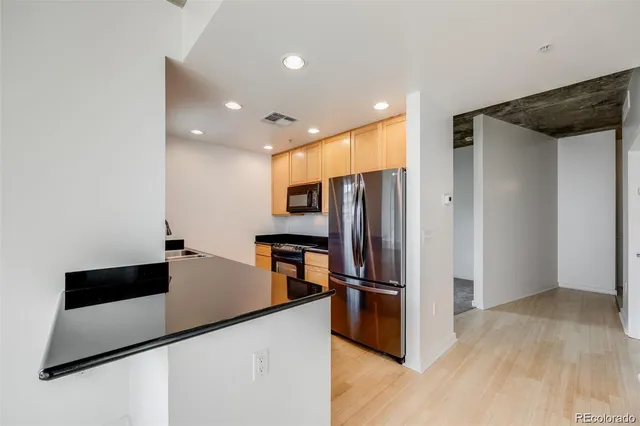 a kitchen with stainless steel appliances granite countertop a refrigerator a sink and a stove