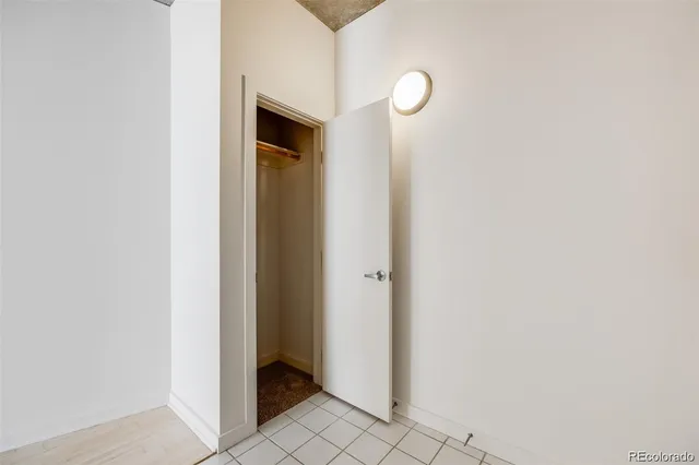 a view of a hallway with wooden floor and a bathroom