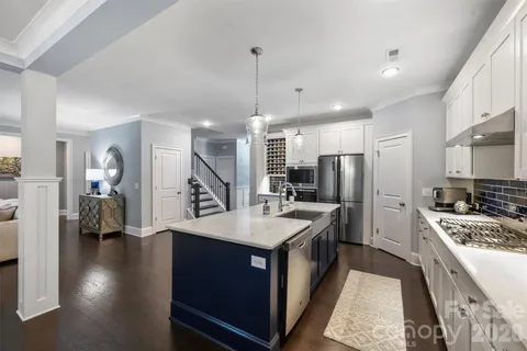 a kitchen with refrigerator a sink and wooden floor