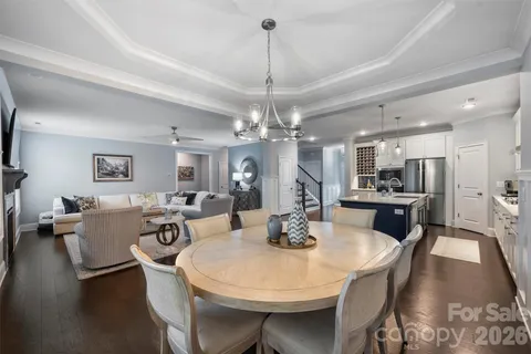 a view of a dining room with furniture a chandelier and wooden floor