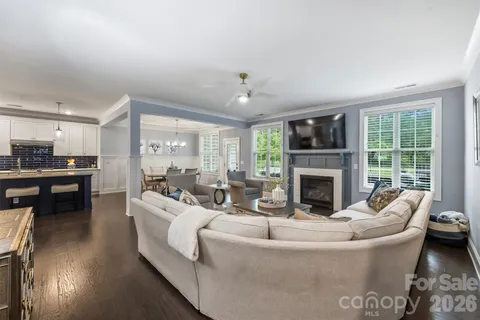 a living room with furniture fireplace and a large window