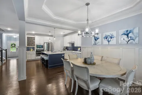 a dining room with furniture a chandelier and wooden floor