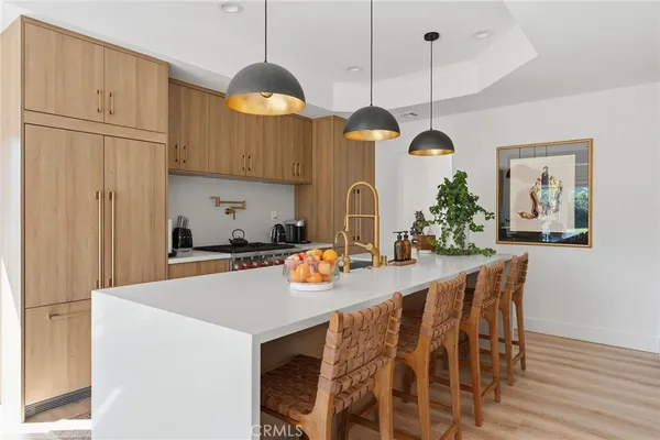 a kitchen with a refrigerator a sink and a chandelier