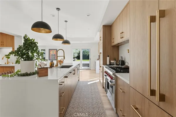 a kitchen with stainless steel appliances kitchen island granite countertop a stove a sink and a refrigerator