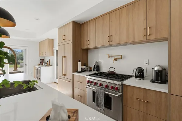 a kitchen with stainless steel appliances granite countertop a stove a sink and a white cabinets