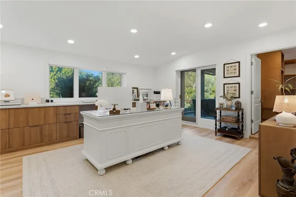 a living room with stainless steel appliances kitchen island furniture and a large window
