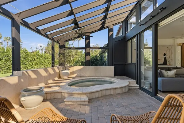 a living room with patio furniture and a floor to ceiling window
