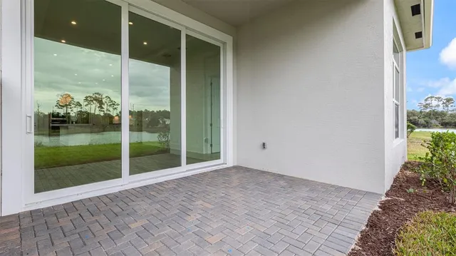 a view of a room with a large window and wooden floor