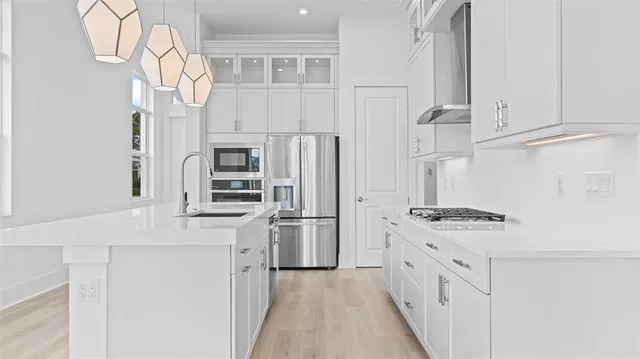 a kitchen with stainless steel appliances granite countertop a refrigerator a stove and a sink