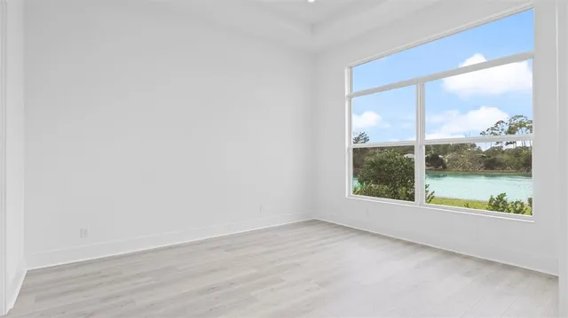an empty room with wooden floor and a window